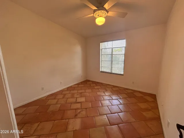 an empty room with windows and fan