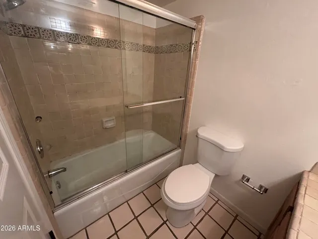 a white toilet sitting next to a bath tub