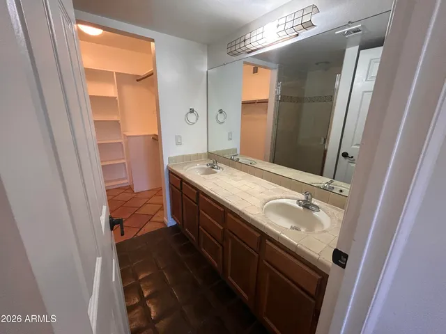 a bathroom with a granite countertop sink a mirror and a shower