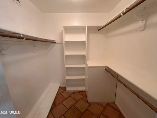 a view of walk in closet with empty racks
