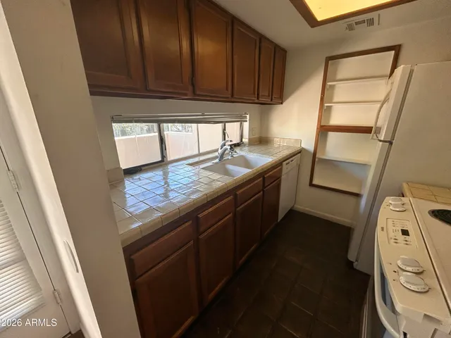a kitchen with granite countertop wood cabinets and a sink