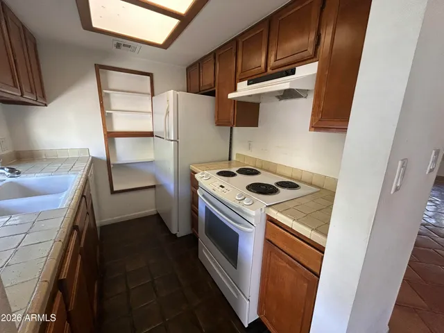 a kitchen with a stove sink and refrigerator