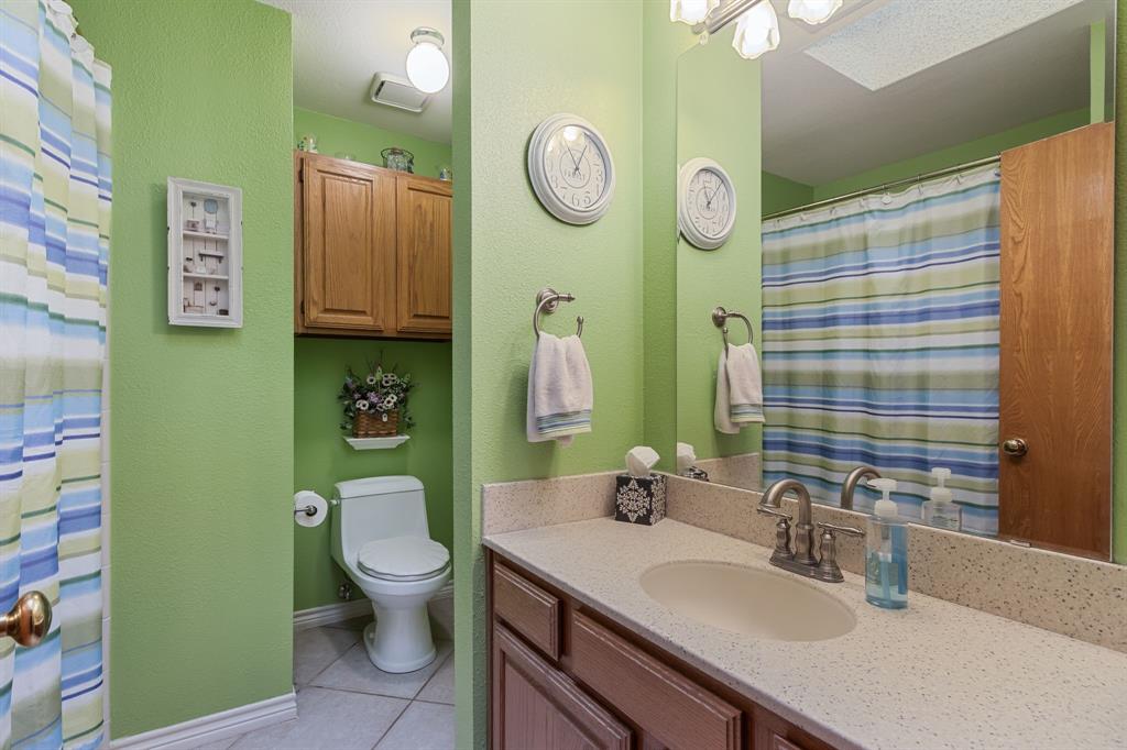 2708 Whitby Lane Grapevine, TX 76051 - Photo 23 of 32 a bathroom with a granite countertop toilet sink and mirror