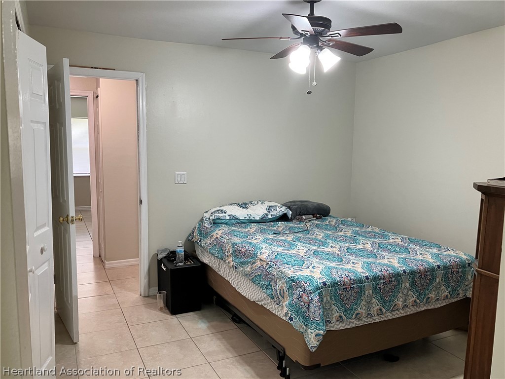 4010 Leaf Road Sebring, FL 33875 - Photo 13 of 35 a bedroom with a bed and a chandelier