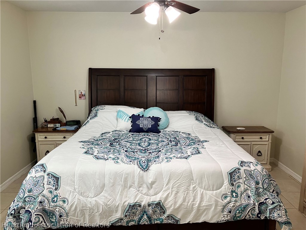 4010 Leaf Road Sebring, FL 33875 - Photo 9 of 35 a bedroom with a bed and a chandelier