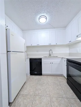 a kitchen with stainless steel appliances a refrigerator sink and cabinets