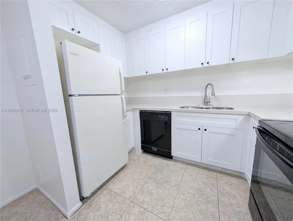 a kitchen with white cabinets and appliances