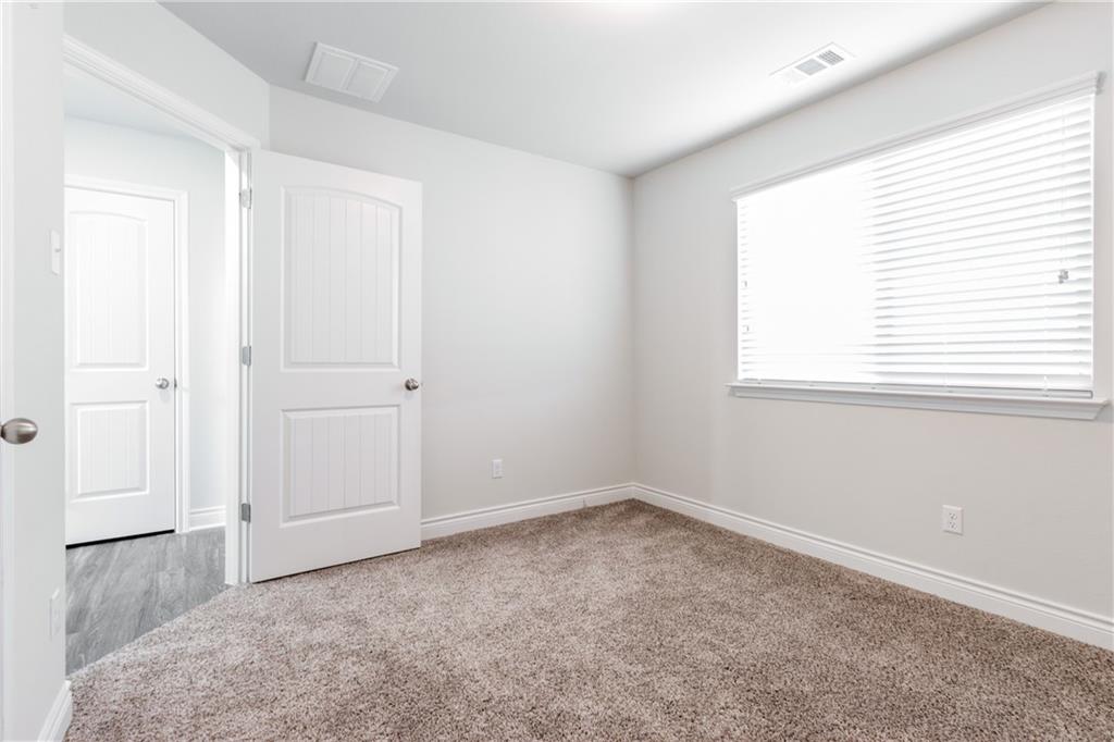 2104 Pindos Pony Way Georgetown, TX 78626 - Photo 24 of 30 Sun-filled bedroom featuring plush carpeting and pristine white doors, ready for personalized touches.