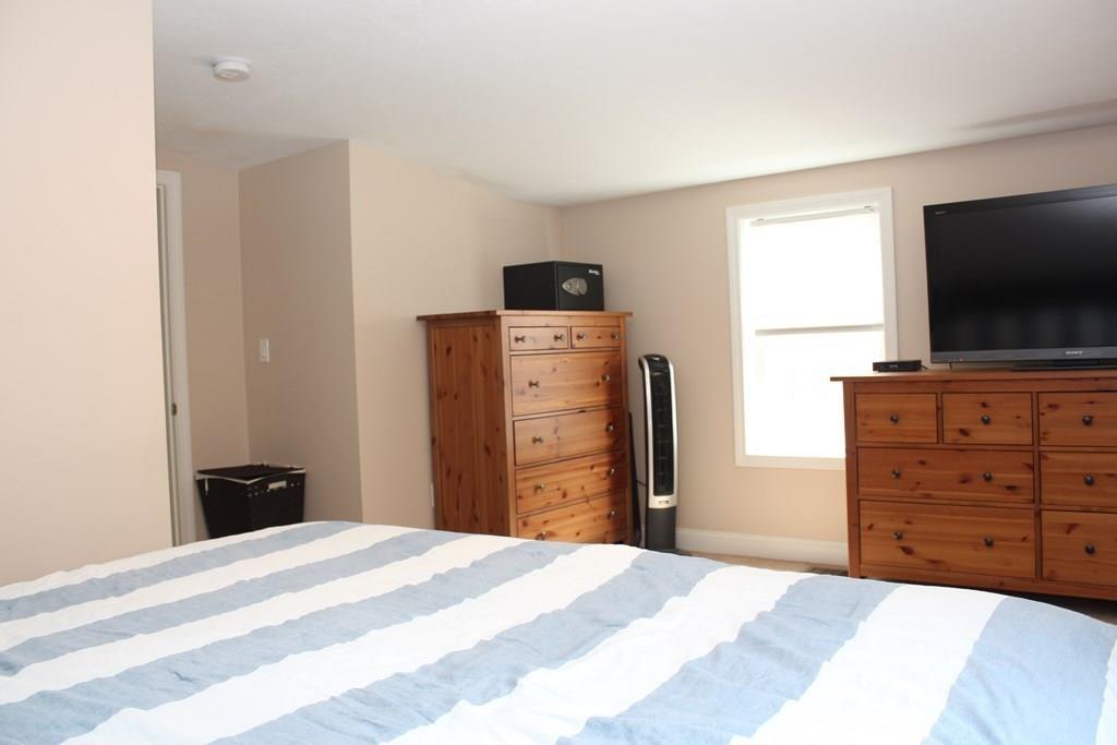 33 Riverside Drive North Reading, MA 01864 - Photo 23 of 37 a bedroom with a bed and a flat screen tv