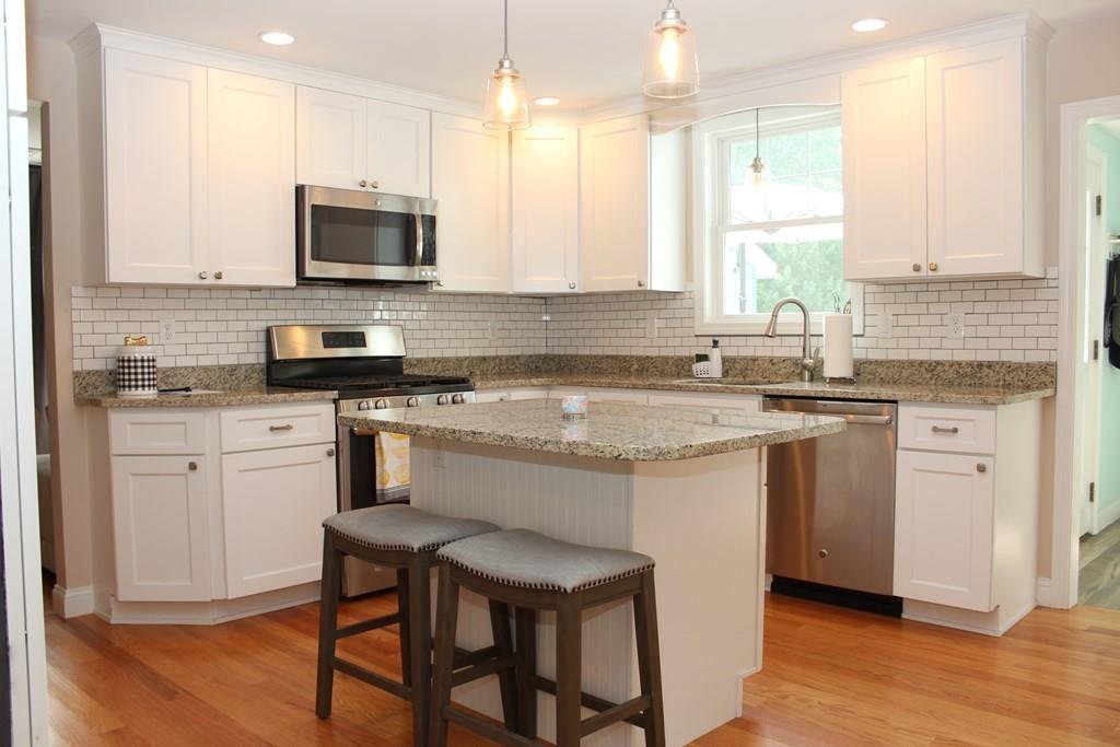 33 Riverside Drive North Reading, MA 01864 - Photo 8 of 37 a kitchen with granite countertop white cabinets and white appliances