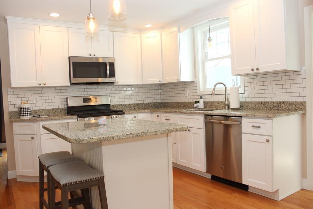 33 Riverside Drive North Reading, MA 01864 - Photo 9 of 37 a kitchen with stainless steel appliances granite countertop a sink a stove and a microwave