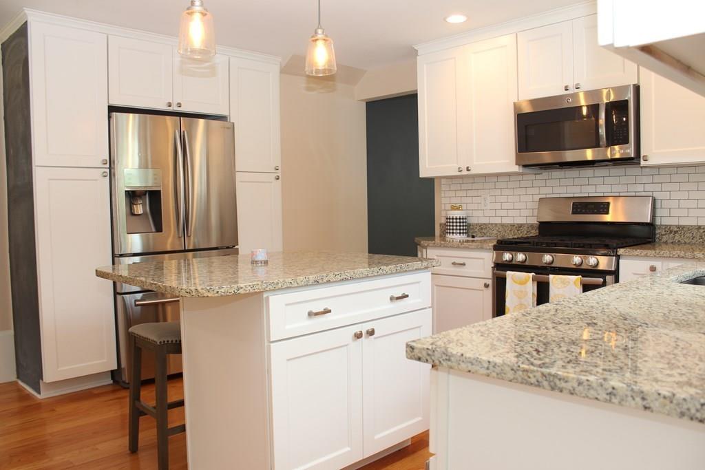 33 Riverside Drive North Reading, MA 01864 - Photo 10 of 37 a kitchen with stainless steel appliances kitchen island granite countertop a refrigerator stove and microwave