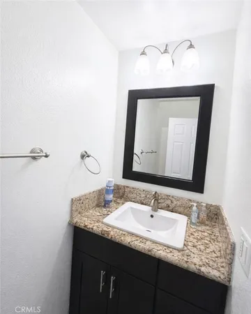 a bathroom with a granite countertop sink and a mirror