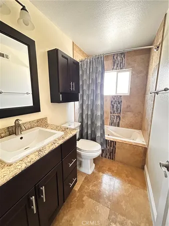 a bathroom with a granite countertop sink toilet and shower