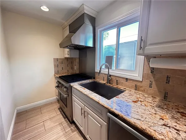 a kitchen with a sink stove and cabinets