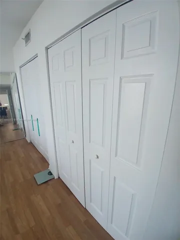 a view of a hallway with wooden floor and entryway