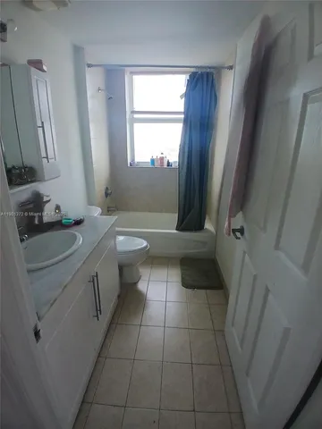 a bathroom with a granite countertop sink a toilet and a mirror