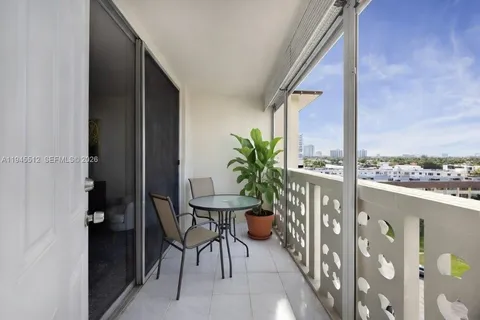 a balcony with chairs and potted plants