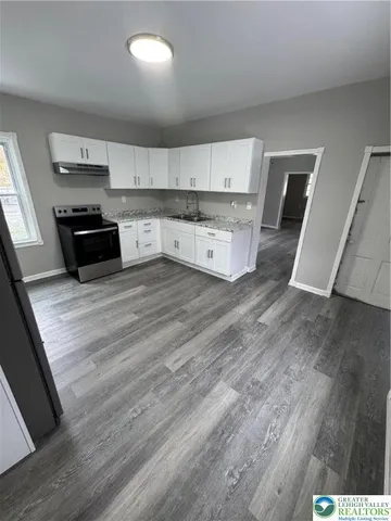 a kitchen with granite countertop a stove and cabinets