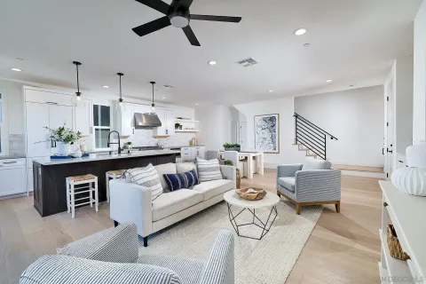 a living room with furniture kitchen view and a chandelier