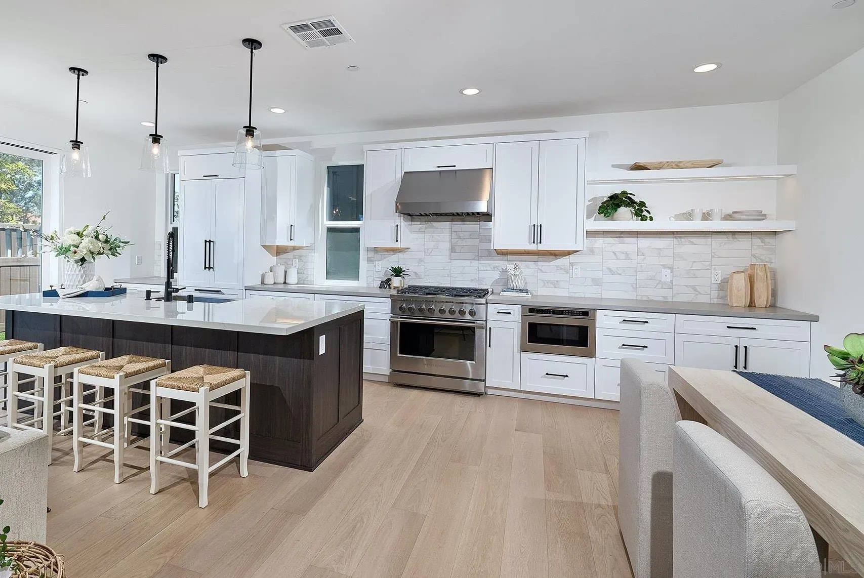 557 North Vulcan Avenue Encinitas, CA 92024 - Photo 5 of 27 a kitchen with stainless steel appliances a stove a sink dishwasher a oven with white cabinets and wooden floor