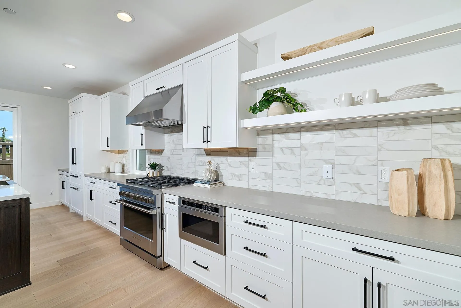 557 North Vulcan Avenue Encinitas, CA 92024 - Photo 6 of 27 a kitchen with granite countertop a sink a stove and cabinets