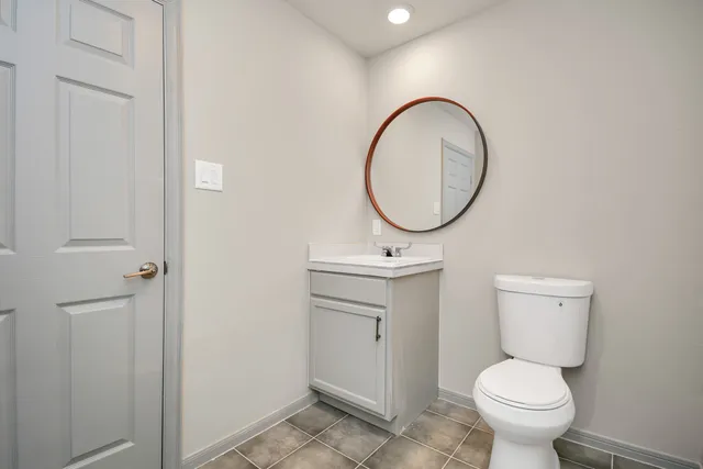 a bathroom with a toilet a sink and a mirror