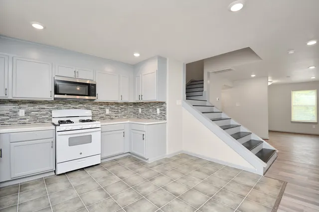 a kitchen with granite countertop a sink and white cabinets