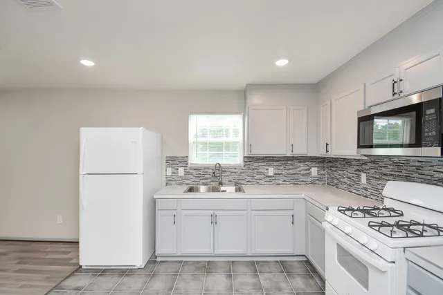 a kitchen with a stove a sink and a refrigerator