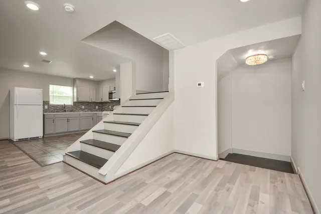 a view of kitchen with sink and refrigerator
