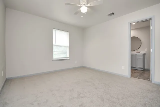 an empty room with a bathroom and a window