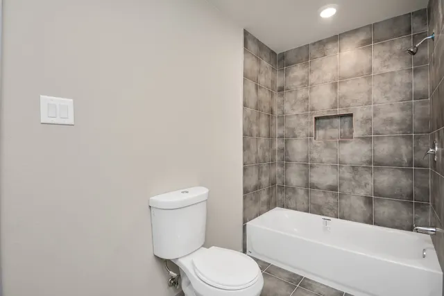a white toilet sitting next to a bath tub and a shower