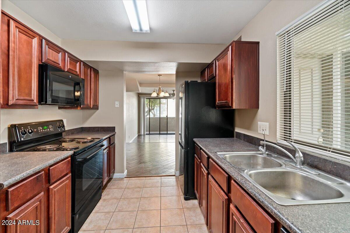 10115 East Mountain View Road, Unit 1102 Scottsdale, AZ 85258 - Photo 16 of 31 a kitchen with stainless steel appliances granite countertop a sink a stove and a refrigerator