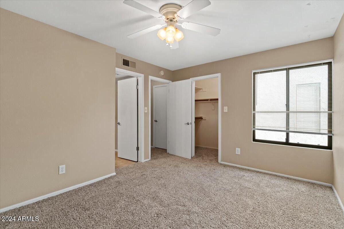 10115 East Mountain View Road, Unit 1102 Scottsdale, AZ 85258 - Photo 24 of 31 an empty room with chandelier fan and windows