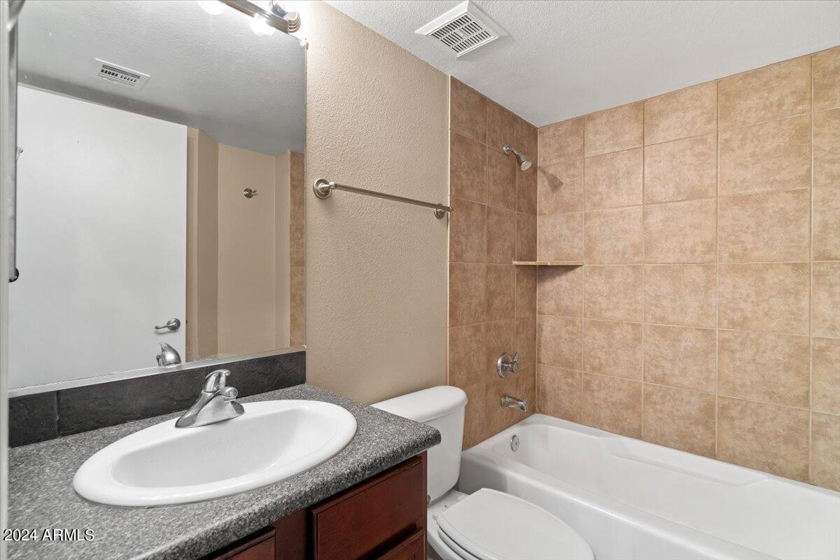 10115 East Mountain View Road, Unit 1102 Scottsdale, AZ 85258 - Photo 25 of 31 a bathroom with a granite countertop sink toilet and shower