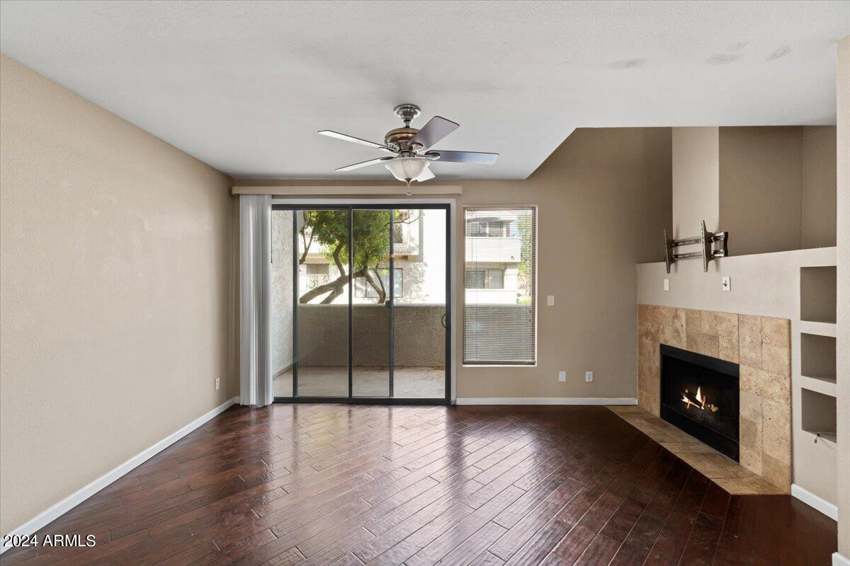 10115 East Mountain View Road, Unit 1102 Scottsdale, AZ 85258 - Photo 9 of 31 an empty room with wooden floor fireplace and windows