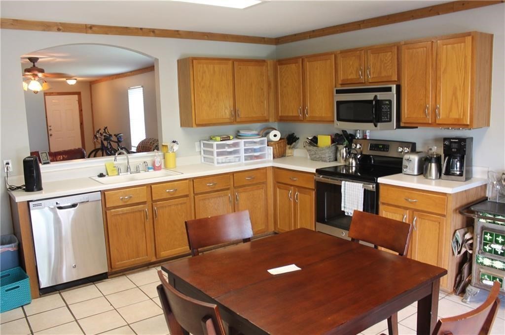 150 Madisons Way Buda, TX 78610 - Photo 3 of 11 a kitchen with stainless steel appliances granite countertop a sink a stove cabinets dining table and chairs