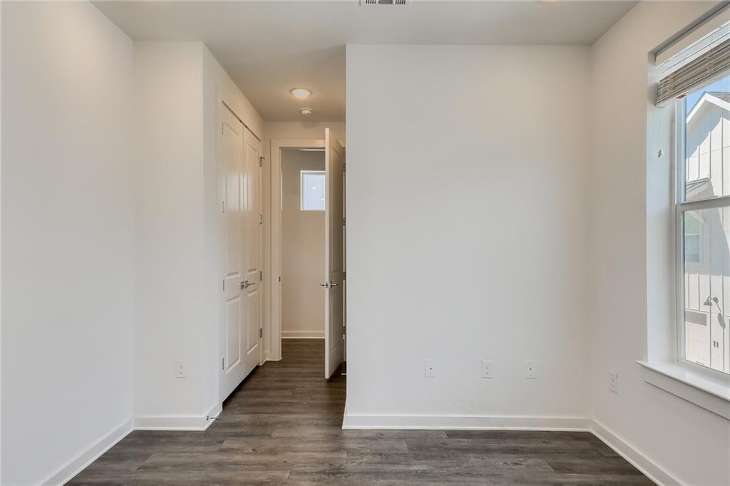 2624 Metcalfe Road, Unit 7 Austin, TX 78741 - Photo 19 of 31 Interior space featuring wood-finish flooring, white walls, and a window with blinds