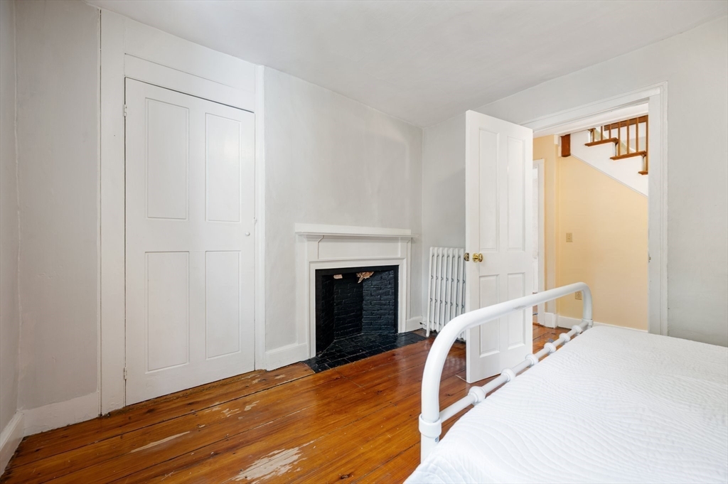 651 Main Street Hingham, MA 02043 - Photo 23 of 42 a bedroom with a bed and a fireplace