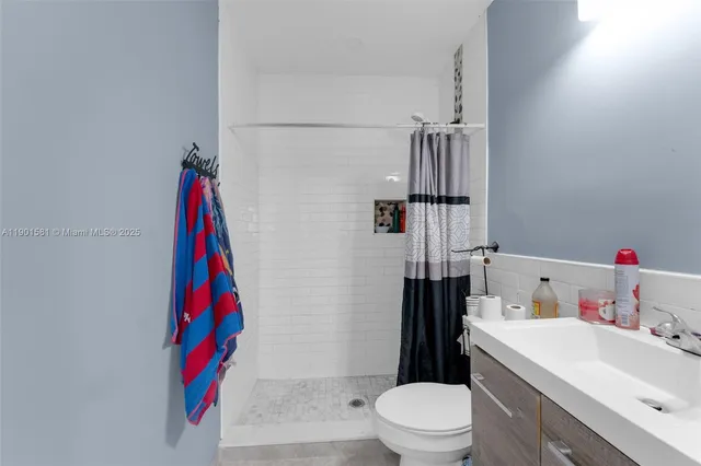 a bathroom with a sink vanity mirror and toilet