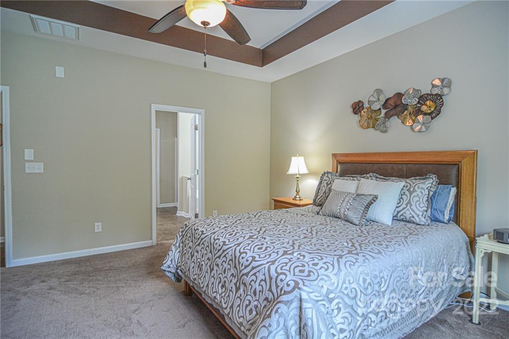 1672 Beleek Ridge Lane Clover, SC 29710 - Photo 12 of 32 a bedroom with a large bed and a chandelier