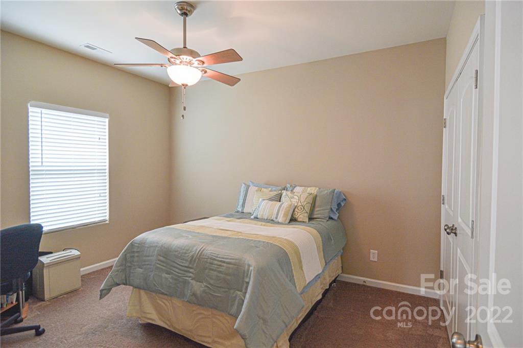 1672 Beleek Ridge Lane Clover, SC 29710 - Photo 17 of 32 a bedroom with a bed and a chandelier