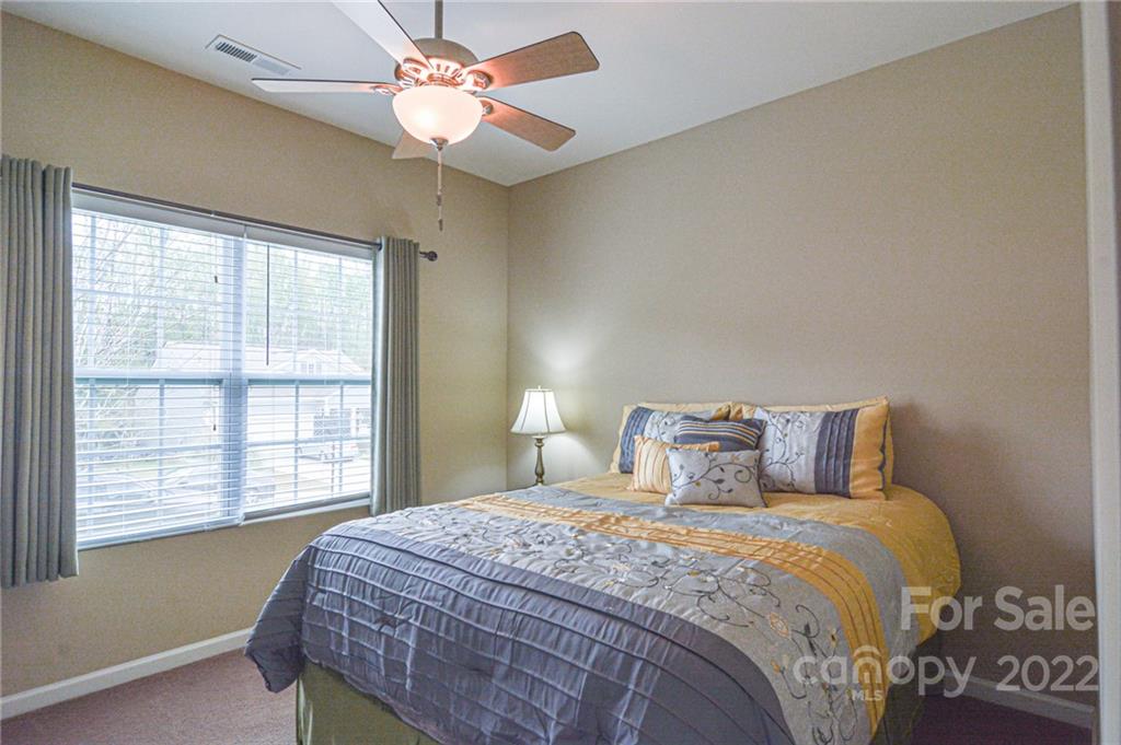 1672 Beleek Ridge Lane Clover, SC 29710 - Photo 19 of 32 a bedroom with a large bed and a chandelier