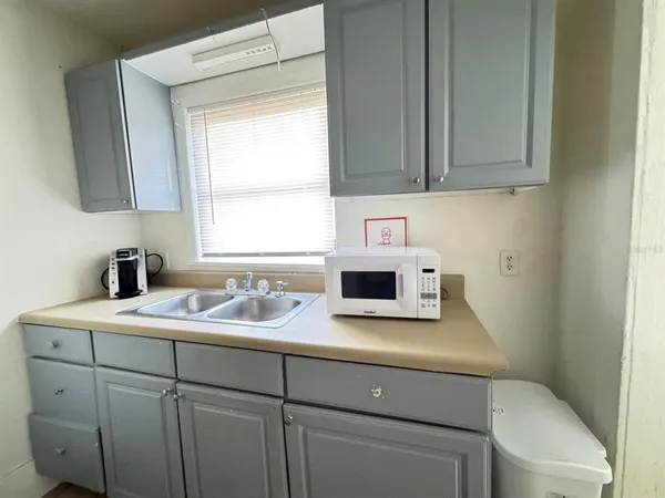 a kitchen with a sink cabinets and a window
