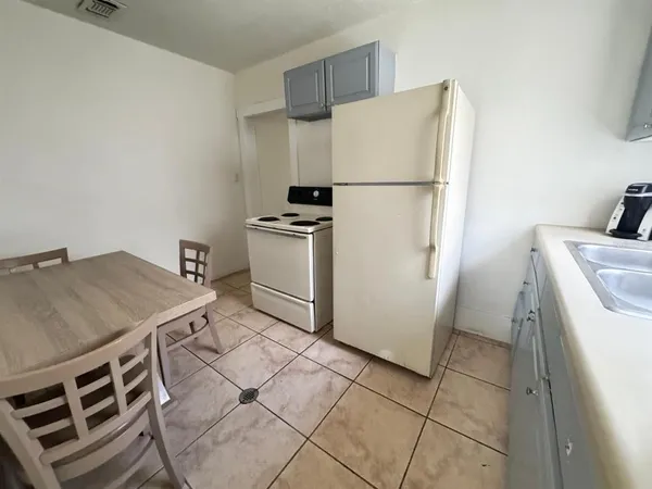 a kitchen with a stove a refrigerator and a sink