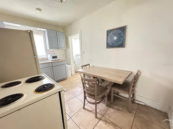a kitchen with a stove a refrigerator and a dining table