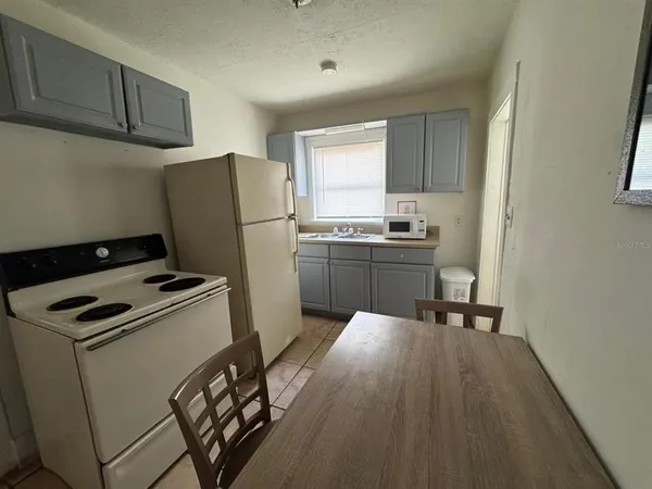 a kitchen with a refrigerator a stove top oven a sink and cabinets