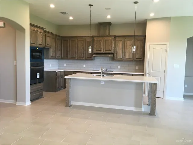 a kitchen with kitchen island a sink stainless steel appliances and cabinets