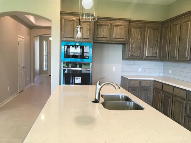 a kitchen with stainless steel appliances granite countertop a sink and a refrigerator