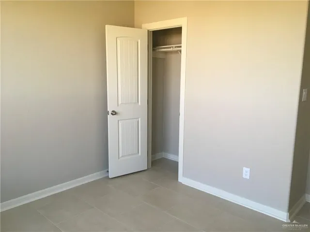 an empty room with closet and a hallway
